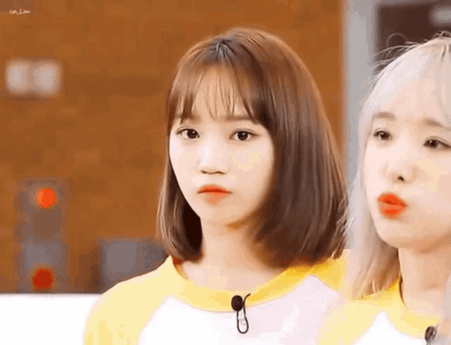 two girls with short hair are standing next to each other .
