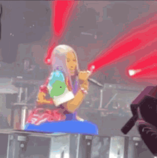 a woman is singing into a microphone on a stage while wearing a jacket that says s on it .