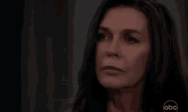 a close up of a woman 's face in a dark room .