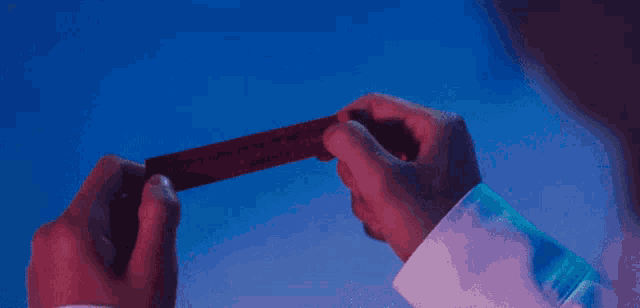 a man in a white shirt is holding a red object