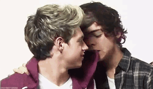 a couple of men are kissing each other on the cheek .