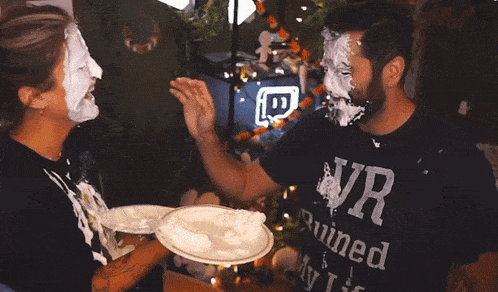 a man wearing a shirt that says ruined on it is covered in cake