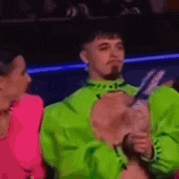 a man in a neon green jacket is standing next to a woman .