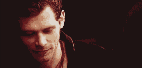 a close up of a man 's face with his eyes closed and smiling .
