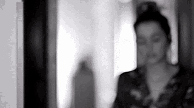 a black and white photo of a woman in a room .