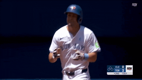 a baseball player wearing a blue jays uniform is running towards home plate