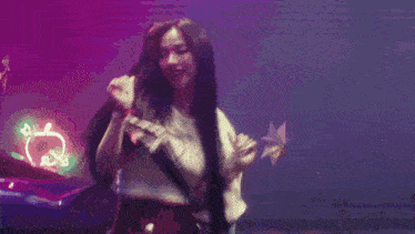a woman with long hair is singing into a microphone while wearing a hat .
