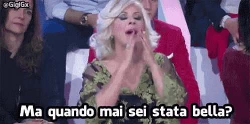 a woman in a green dress is sitting in a crowd and says ma quando mai sei stata bella