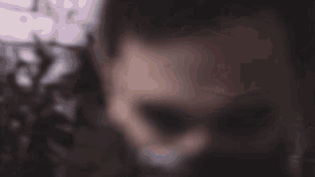 a blurry picture of a person 's face with a blurred background of trees