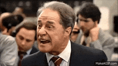 an older man in a suit and tie is making a funny face .