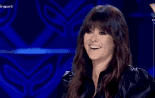 a woman is smiling in front of a blue background with the word singers on it