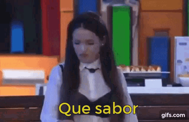 a woman with long hair is sitting on a bench with the words que sabor written in yellow .
