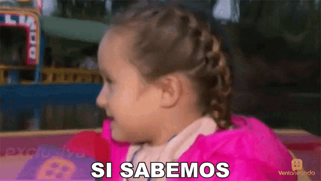 a little girl in a pink jacket says si sabemos in spanish