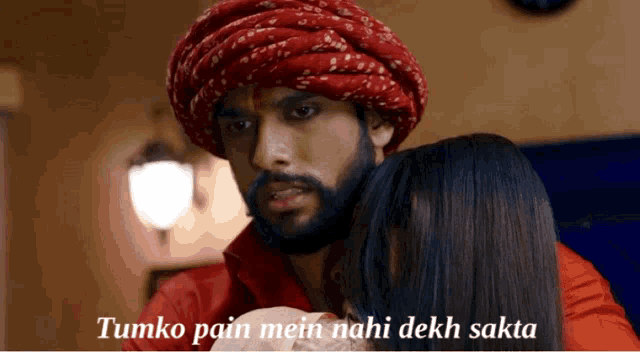 a man in a turban holds a woman in his arms with the words tumko pain mein nahi dekh sakta below him