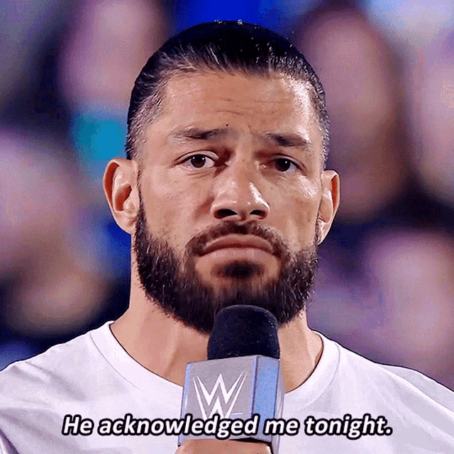 a man with a beard is talking into a microphone with the words he acknowledged me tonight above him