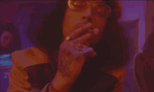 a woman smoking a cigarette in a dark room