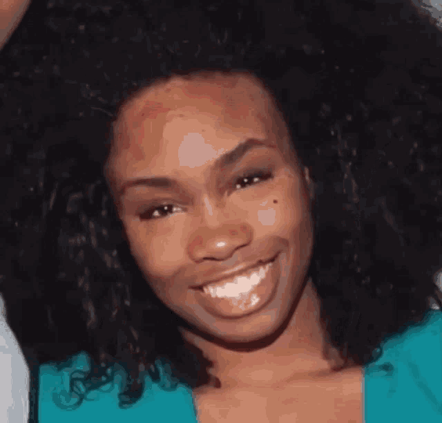 a close up of a woman 's face with a big afro .