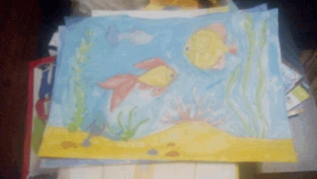a child 's drawing of fish and seaweed on a blue background