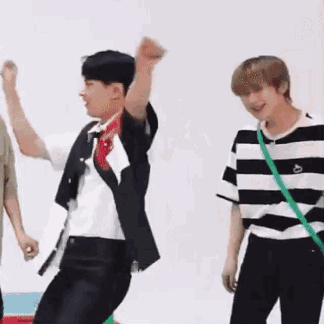a group of young men are standing next to each other dancing .