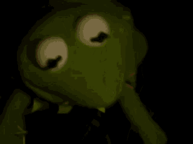 kermit the frog is holding a syringe in his mouth in the dark .