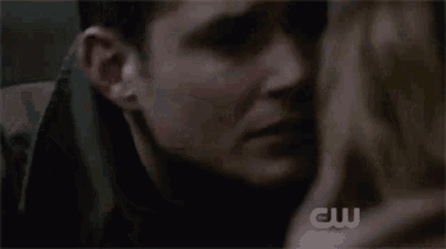 a man and a woman are kissing each other in a close up of their faces .