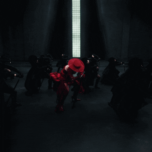 a woman in a red hat is surrounded by people in black
