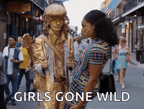 a statue of a man holding a guitar is standing next to a woman with the words girls gone wild written on the bottom