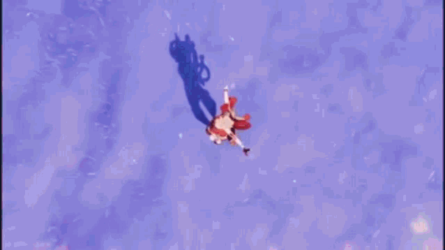 a woman in a red dress is flying through a blue circle