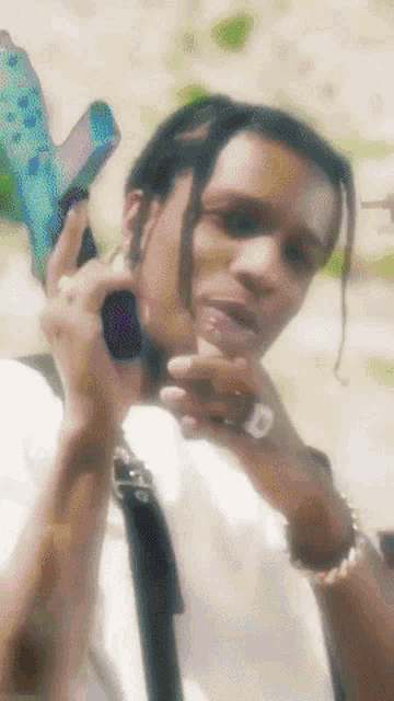 a close up of a man holding a gun with the letter d on his finger