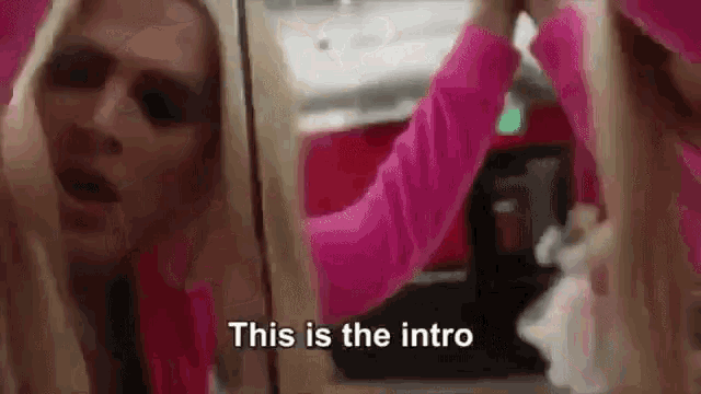 a woman in a pink dress is standing in front of a mirror .