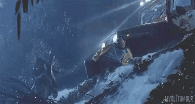 a man in a yellow jacket is standing in the snow near a waterfall in a movie scene ..