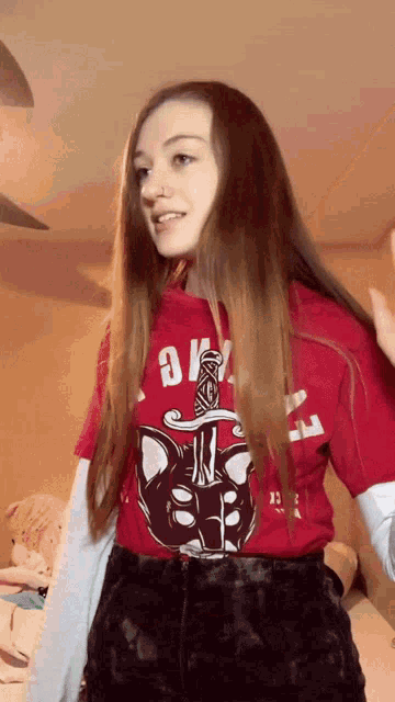 a girl wearing a red shirt with a cat on it