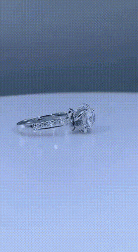 a close up of a person holding a diamond ring on their finger