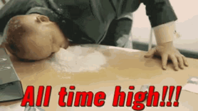 a baby laying on a table with the words all time high in red