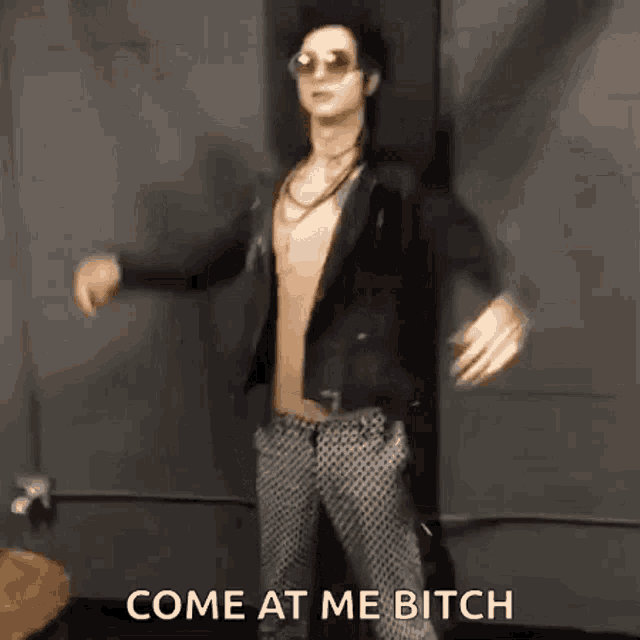 a man without a shirt is dancing in a room with the words `` come at me bitch '' .