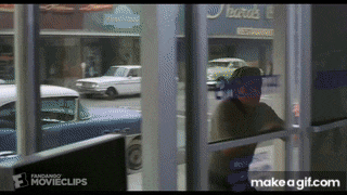 a man is standing in front of a window with a reflection of cars in the window ..