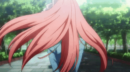 a girl with long red hair is walking down a path