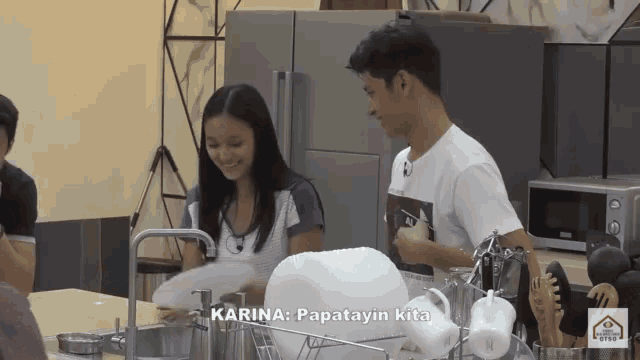 a man and a woman are washing dishes in a kitchen with the words karina papatayin kita on the bottom right