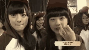 a group of girls are wearing hooded sweatshirts and hats