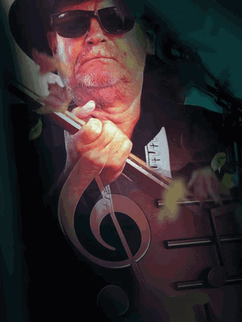 a man wearing sunglasses and a hat holds a musical note