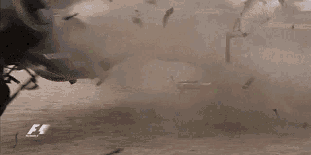 a car that has crashed on a race track with a f1 logo on the side