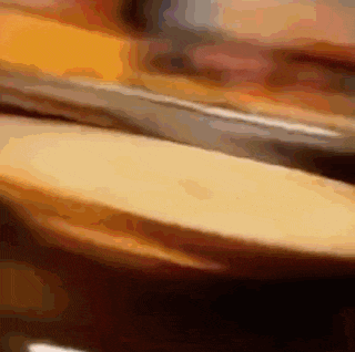 a close up of a knife cutting a piece of bread
