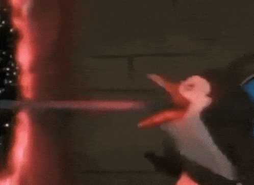 a penguin is holding a toothbrush in front of a toothpaste dispenser