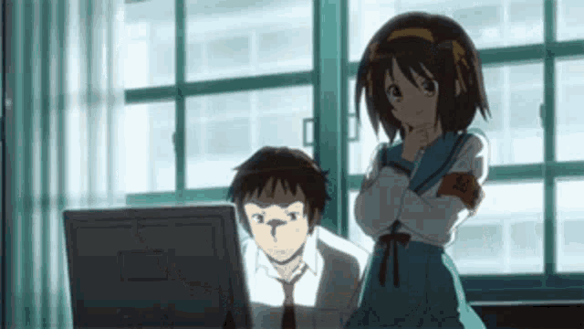 a man and a girl are sitting in front of a computer .