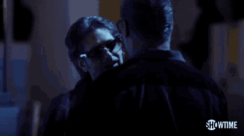 two men are hugging in a dark room and one of them is saying nope