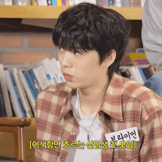 a young man wearing a plaid shirt has a name tag on his chest that says ' bo '