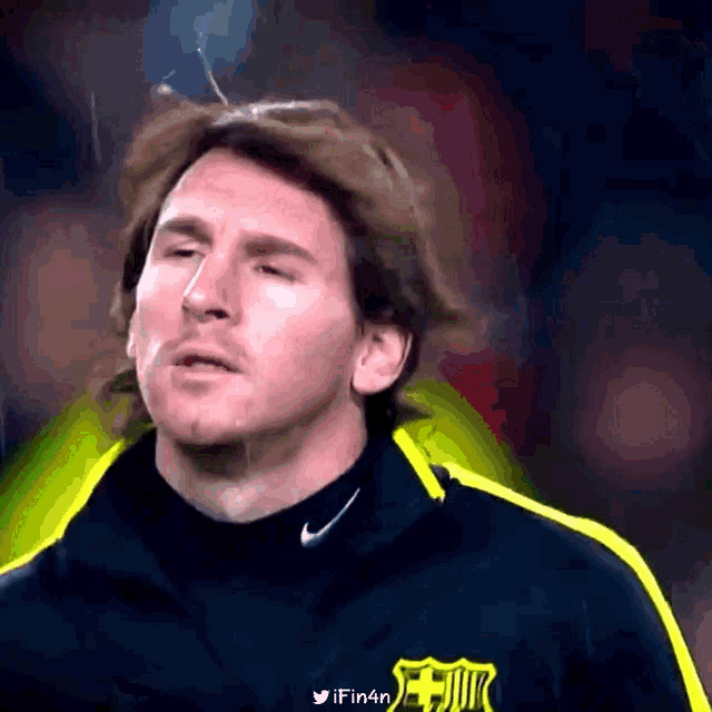 a close up of a man wearing a nike jacket with a fc barcelona logo on it