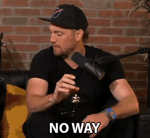 a man sitting in front of a microphone with the words no way written on the bottom