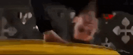 a man is doing a handstand on a yellow car while another man watches .