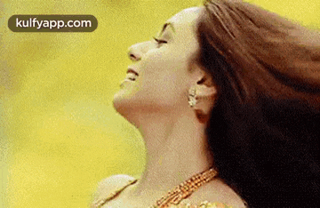 a close up of a woman 's face with her eyes closed and her hair flying in the wind .